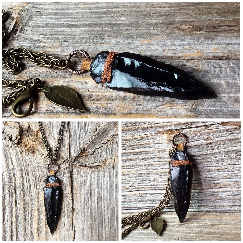 Puede incluir: Un collar con un colgante de punta de flecha de obsidiana negra, envuelto en cuero marr&oacute;n y una cadena de lat&oacute;n. El collar tiene un peque&ntilde;o dije de hoja de lat&oacute;n.