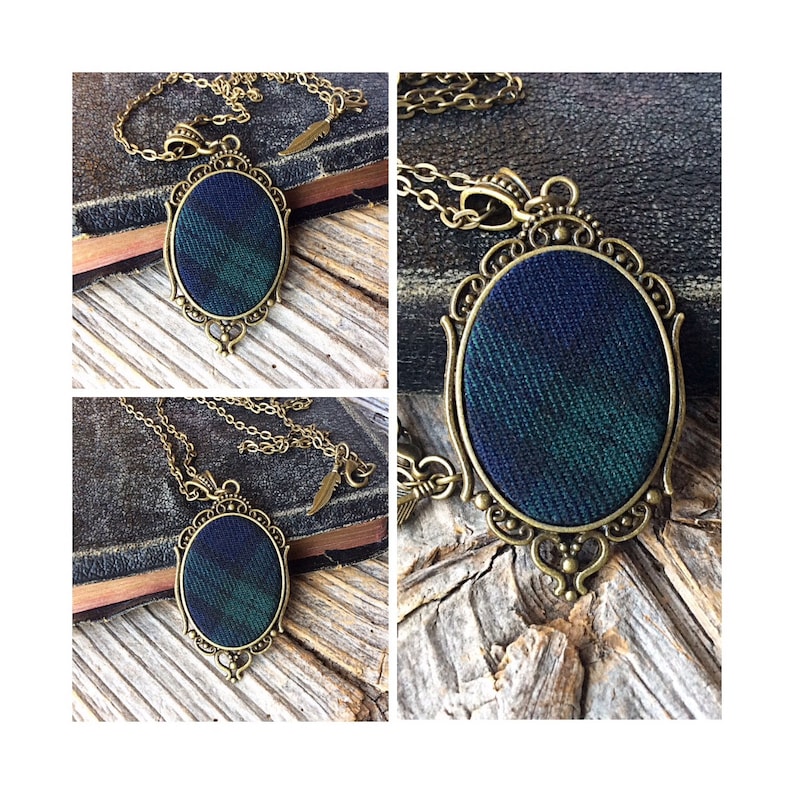 May include: A gold chain necklace with a pendant featuring a dark blue, green, and black plaid fabric design in an oval frame.