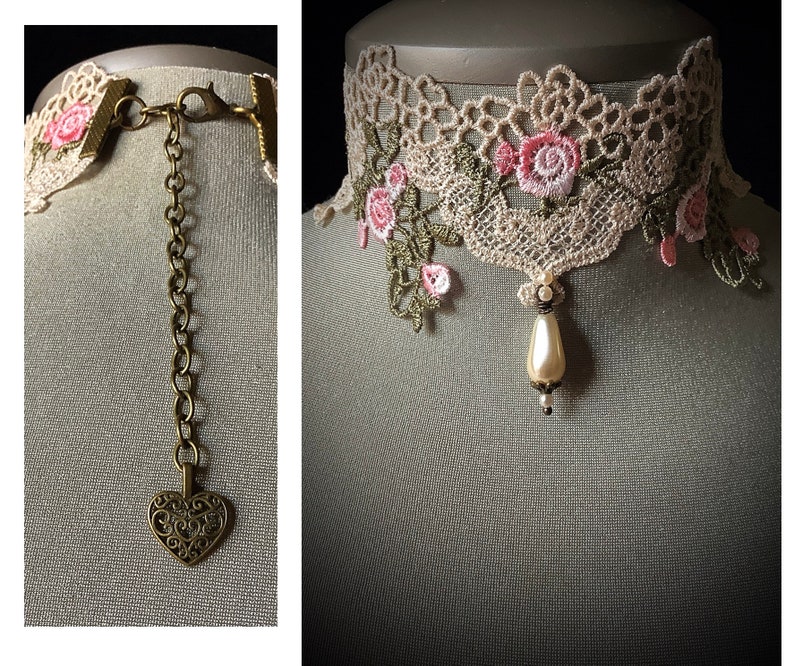 Puede incluir: Un delicado collar de encaje marfil con bordados florales rosas y un colgante de perla. El collar tiene una cadena de bronce con un dije en forma de coraz&oacute;n.