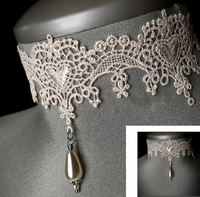 May include: A delicate ivory lace choker necklace with a single pearl pendant. The choker is made of intricate lacework and has a delicate, feminine look.
