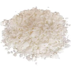 May include: A close-up of a pile of white wax flakes. The flakes are small and irregular in shape, and they are piled high in the center of the image.