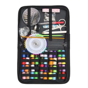 Puede incluir: Una caja negra con cremallera llena de art&iacute;culos de costura, incluyendo carretes de hilo de varios colores, agujas, alfileres, un dedal y unas tijeras peque&ntilde;as.