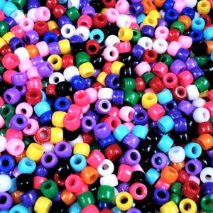 May include: A large assortment of colorful plastic beads. The beads are round and have a hole in the center. The beads are in a variety of colors, including red, blue, green, yellow, orange, purple, pink, and white.