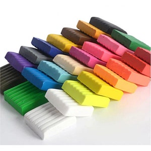May include: A set of 24 colourful modelling clay bars, arranged in a staggered stack. The clay bars are in various shades of red, orange, yellow, green, blue, purple, brown, and white.