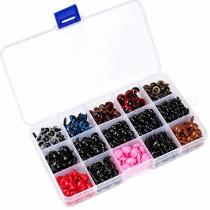 May include: A clear plastic storage container with a blue latch, filled with various sizes and colors of plastic safety eyes for crafts. The compartments contain black, brown, red, pink, blue, and clear eyes, each featuring a threaded screw back.