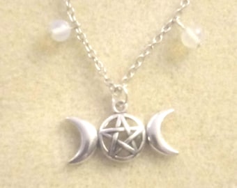 May include: A silver necklace with a triple moon and pentagram pendant. The necklace has three small white beads hanging from it.