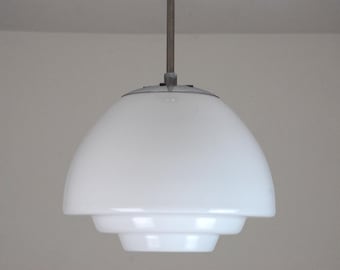 May include: A white, tiered, dome-shaped pendant light fixture with a silver metal hanging cord.
