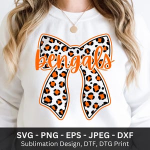 Pode incluir: Camisola branca com um grande design de la&ccedil;o com estampa de leopardo em preto, laranja e branco. A palavra "bengals" est&aacute; escrita em laranja na fita. A parte inferior da imagem inclui texto: SVG - PNG - EPS - JPEG - DXF.