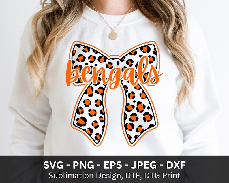 Pode incluir: Camisola branca com um grande design de la&ccedil;o com estampa de leopardo em preto, laranja e branco. A palavra "bengals" est&aacute; escrita em laranja na fita. A parte inferior da imagem inclui texto: SVG - PNG - EPS - JPEG - DXF.