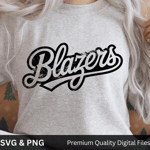 May include: A light gray sweatshirt with the word "Blazers" in a distressed black and white design. The text is in a vintage, cursive font. The bottom of the image has the text "SVG & PNG" and "Premium Quality Digital Files".