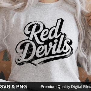 May include: A light gray sweatshirt with the words "Red Devils" in a distressed black and white design. The text is in a bold, stylized font. Below the text are the words "SVG & PNG" and "Premium Quality Digital Files".