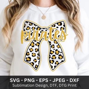 Può includere: Felpa bianca con un grande design a fiocco con stampa leopardata e la scritta "Pirates" in lettere dorate. Il fiocco ha un contorno nero. La parte inferiore dell'immagine include il testo "SVG - PNG - EPS - JPEG - DXF".