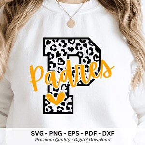 May include: A white sweatshirt featuring a large black and white leopard print letter P with heart shapes. The word Padres is written in yellow cursive script across the letter, and a yellow heart is positioned at the base of the letter P.