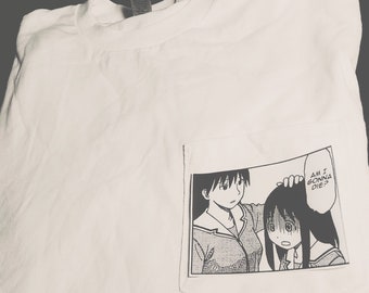 May include: White t-shirt with a pocket featuring a black and white manga panel. The panel shows two female characters, one touching the other's head, with the text "AM I GONNA DIE?" in a speech bubble.