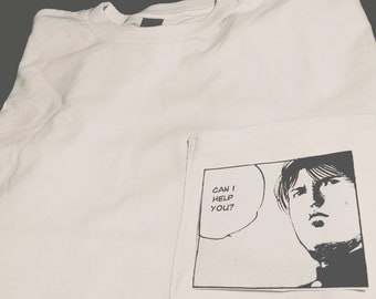 May include: White t-shirt with a black and white graphic of a manga character in a pocket. The graphic says "Can I help you?"