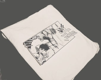 Op de afbeelding: Een wit T-shirt met een zwart-wit manga-illustratie van twee boksers die vechten. De illustratie bevat Japanse tekst die "Happy" zegt.