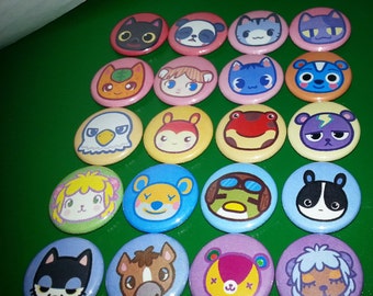 Könnte beinhalten: Eine Sammlung von 18 bunten runden Pins mit verschiedenen Tierfiguren. Die Pins sind aus Metall und haben eine glänzende Oberfläche. Die Figuren umfassen eine Katze, einen Hund, einen Bären, einen Fuchs, ein Eichhörnchen, einen Vogel, einen Frosch, einen Fisch, eine Schildkröte, einen Schmetterling, einen Marienkäfer, eine Biene, eine Blume, ein Herz, einen Stern, einen Mond, eine Sonne und eine Wolke.