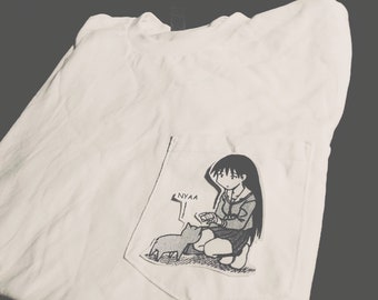 May include: White t-shirt with a pocket featuring a black and white manga-style illustration of a girl and a cat. The girl is kneeling and the cat is sitting. The word "NYAA" is visible.