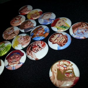 May include: A collection of 15 round pins featuring characters from the Street Fighter video game series. The pins are colorful and feature various characters, including Ryu, Ken, Chun-Li, and Guile.