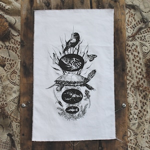 Könnte beinhalten: Schwarz-weiß-Illustration einer Schildkröte, eines Vogels und eines Schmetterlings auf weißem Stoffhintergrund. Die Illustration ist im Vintage-Stil gehalten und verfügt über ein mehrschichtiges Design.