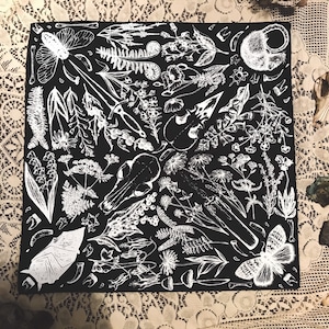 Könnte beinhalten: Schwarzweiß-Illustration eines quadratischen Bandanas mit einem sich wiederholenden Muster aus verschiedenen botanischen und skelettartigen Elementen. Das Design umfasst Blumen, Blätter, Knochen, Schädel und Insekten.