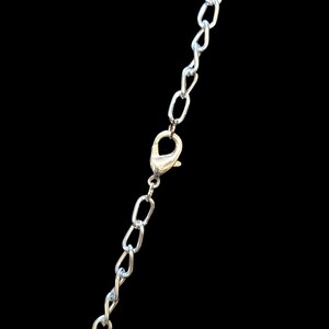 May include: A silver chain necklace with a lobster clasp closure.