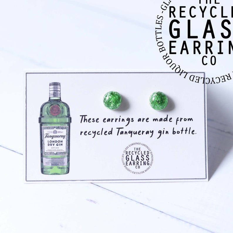 May include: A pair of green glass earrings made from a recycled Tanqueray gin bottle. The earrings are on a white card with a drawing of a Tanqueray gin bottle and the text "These earrings are made from recycled Tanqueray gin bottle."