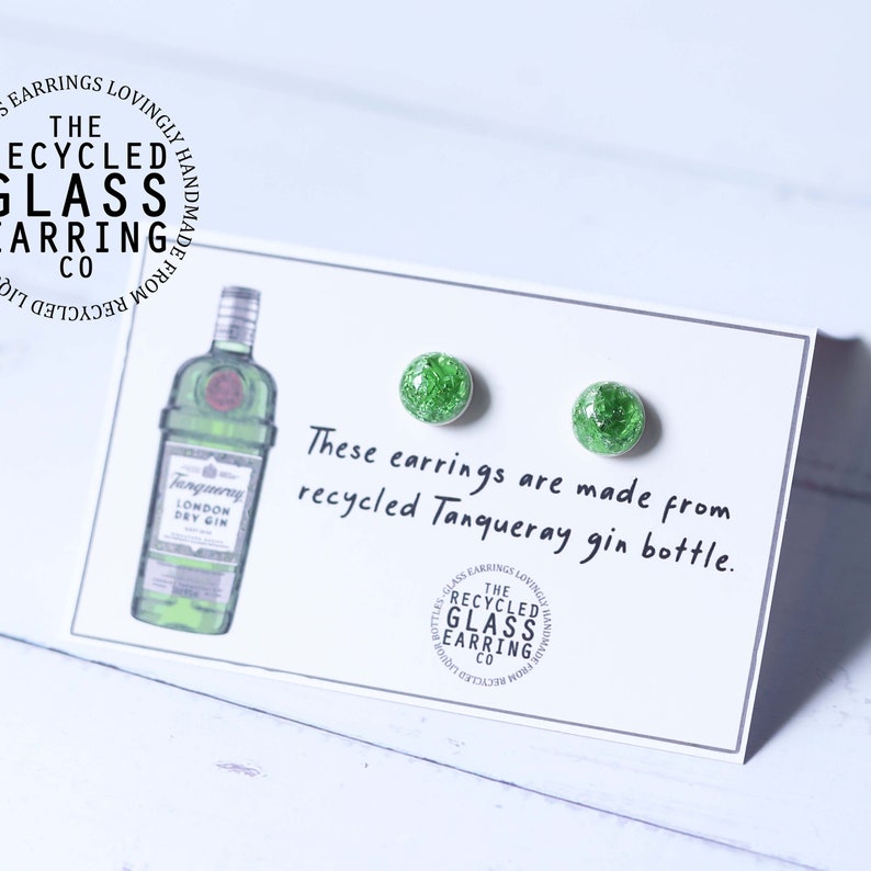 May include: A pair of green glass earrings made from recycled Tanqueray gin bottles. The earrings are on a white card with the text "These earrings are made from recycled Tanqueray gin bottle."