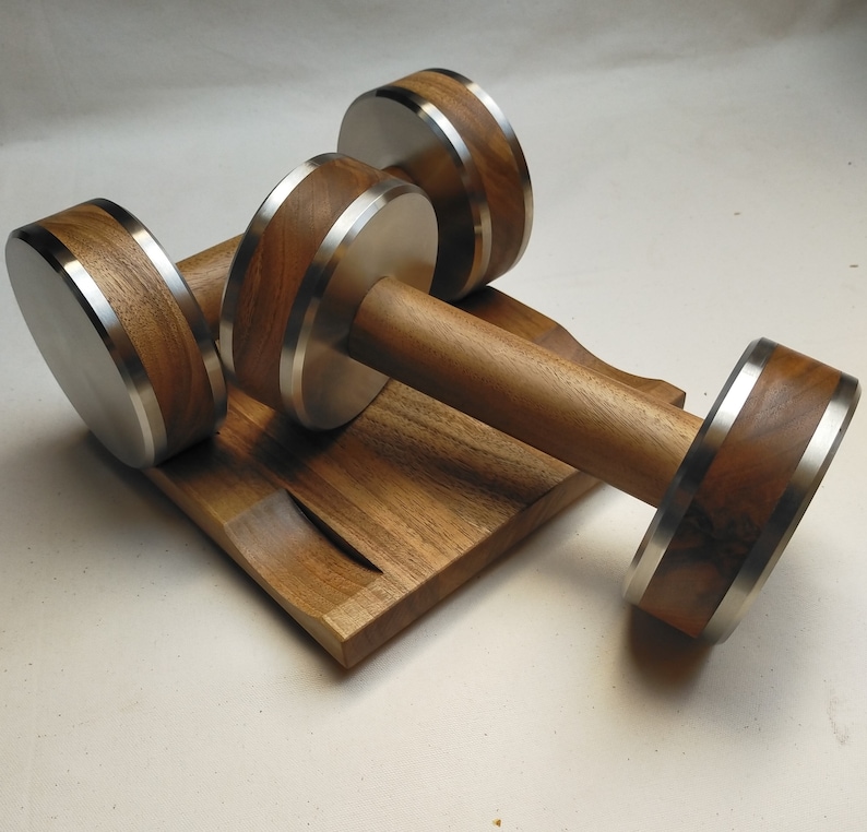 The Coretez dumbbell set, each weighing 6 kg, has smooth-textured wooden handles and stainless steel tips for an elegant look. They come with a matching wooden base for storage. Dumbbells add sophistication to any home gym.