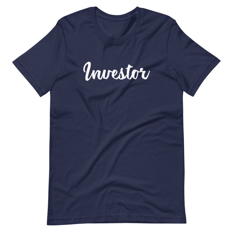 以下が含まれることがあります： 白い筆記体で「Investor」と書かれたネイビーブルーのTシャツです。