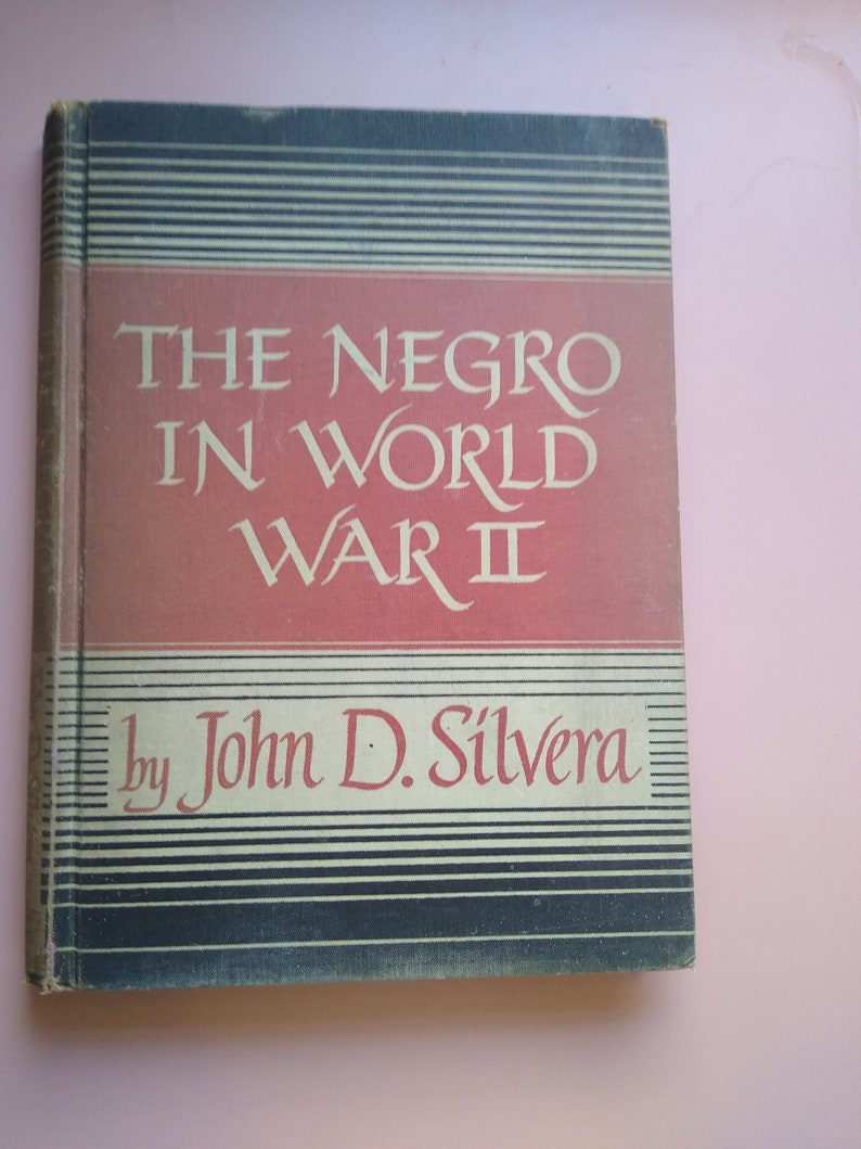May include: A red and black book with the title "The Negro in World War II" by John D. Silv&eacute;ra.