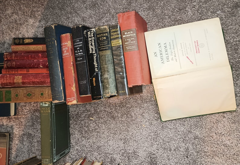 Puede incluir: Una colecci&oacute;n de libros antiguos de tapa dura con t&iacute;tulos como "Uncle Tom's Children", "Black Metropolis", "The Emerging Thought of W.E.B. DuBois", y "An American Dilemma".