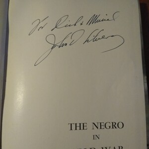 May include: A white book with the title "The Negro in World War II" and a handwritten inscription that reads "For Rich & Muriel, John Oliver."