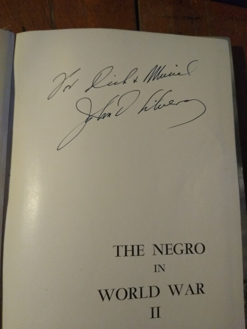 May include: A white book with the title "The Negro in World War II" and a handwritten inscription that reads "For Rich & Muriel, John Oliver."