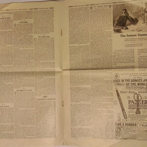 May include: A black and white newspaper page with text and images. The text includes the words "The Instant Summons", "Current Events", and "Used in the Armies and Navies of the World". The images include a group of people in military uniforms, a man writing at a desk, and a Parker fountain pen.