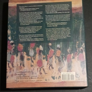 May include: The back cover of a book titled "Souls Grown Deep" with a quote from John Lewis, a member of Congress and cofounder of SNCC. The book is about the civil rights movement and the cultural traditions of Black America. The book is published by Tinwood Books in association with the Schomburg Center for Research in Black Culture, The New York Public Library.