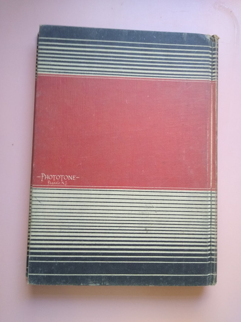 May include: A red book with black and white stripes on the cover. The book has the text "Phototone" and "Passaic, N.J." printed on the cover.