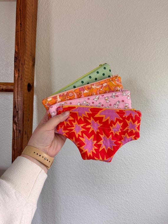 A quilted pouch sewn in the shape of underwear — genuinely clever construction that doubles as a period/tampon holder and conversation-starting purse accessory.
