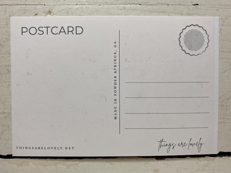 May include: A white rectangular postcard with black text and graphics. The top left reads POSTCARD, the center features a vertical line with MADE IN POWDER SPRINGS, GA, and the bottom right has the script text things are lovely.