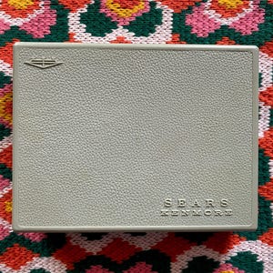 May include: A gray, textured, rectangular box with the words "SEARS KENMORE" printed in white.