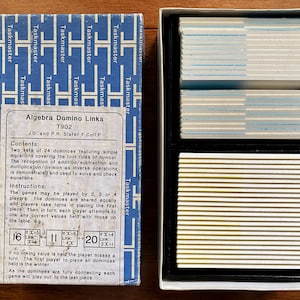 May include: A blue box with the title "Algebra Domino Links" and the text "T902" printed on the front. The box contains two sets of 24 dominoes featuring simple equations covering the four rules of number. The dominoes are used to solve and check equations.