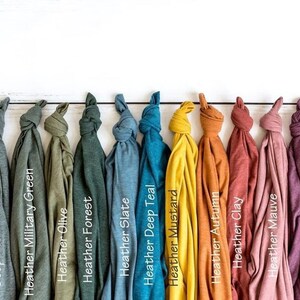 May include: A collection of 13 fabric swatches in various shades of green, blue, yellow, orange, pink, red, and brown. The swatches are arranged in a row and labeled with their color names.