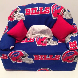 May include: Blue and red tissue box cover shaped like a couch with the words "BILLS" printed on the front. The couch has two red pillows and a white tissue box.