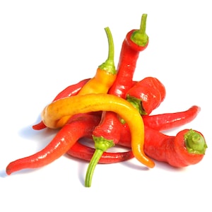 May include: A pile of red and yellow chili peppers with green stems against a white background. The peppers vary in shape and size, with some curved and others straight. The colors range from bright red to a vibrant yellow.