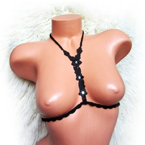 May include: Black crocheted lingerie top with a delicate floral design and rhinestone accents.