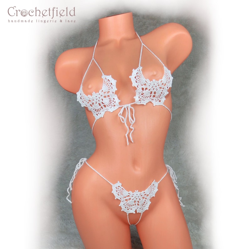 May include: White crocheted lingerie set with a butterfly design. The set includes a bra and a panty with a delicate lace pattern.