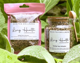 May include: Two packages of herbal tea, one in a pink pouch and the other in a glass jar with a cork lid. Both are labeled "Lung Health" and "herbal tea infusion." A small wooden spoon rests beside the jar, all surrounded by green leaves.