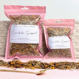 May include: Two pink pouches of herbal tea, labeled "Candida Support" by Meditea Wellness. The tea blend includes ingredients like thyme and calendula. The larger pouch contains 3 oz of tea. A gold spoon rests on the pink surface.