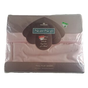May include: A pink full flat sheet packaged in plastic. The packaging features the Cannon brand name and the text "SureSoft finess cotton with the Easy Care of a Blend". The sheet is made of 50% cotton and 50% polyester.