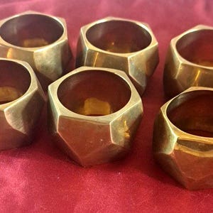 May include: A white ceramic mug with a black handle and the text "But First, Coffee" in a handwritten style. The mug is on a white surface. The mug is 4 inches tall.